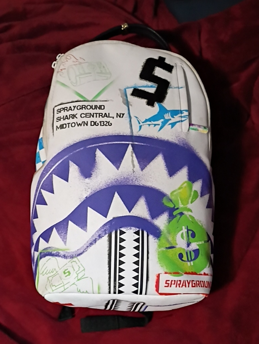 Sprayground White Backpack with Purple Shark Graphic and Green Money-Bag Accents